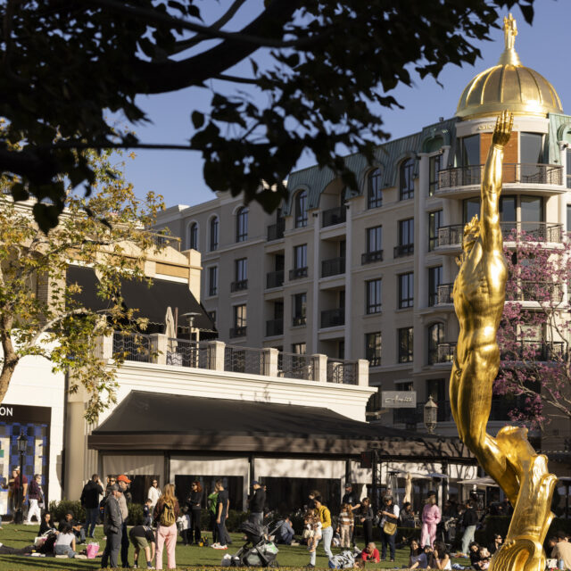 Glendale, California, USA - March 15, 2025: A golden statue anchors a fountain in the heart of a park in The Americana at Brand.